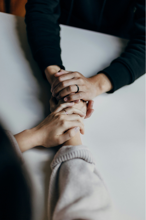 Two people clasping hands in a gesture of mutual support